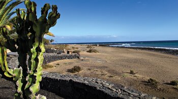 die in schwarzem Lavagestein angelegte Strandpromenade in Puerto del Carmen auf Lanzarote