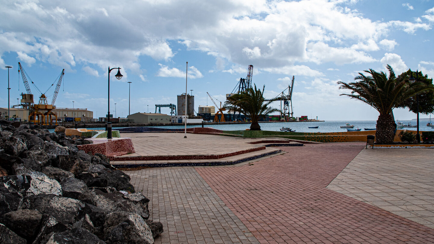 Platz an der Hafenpromenade von Puerto del Rosario auf Fuerteventura mit Loeschkraenen im Hintergrund