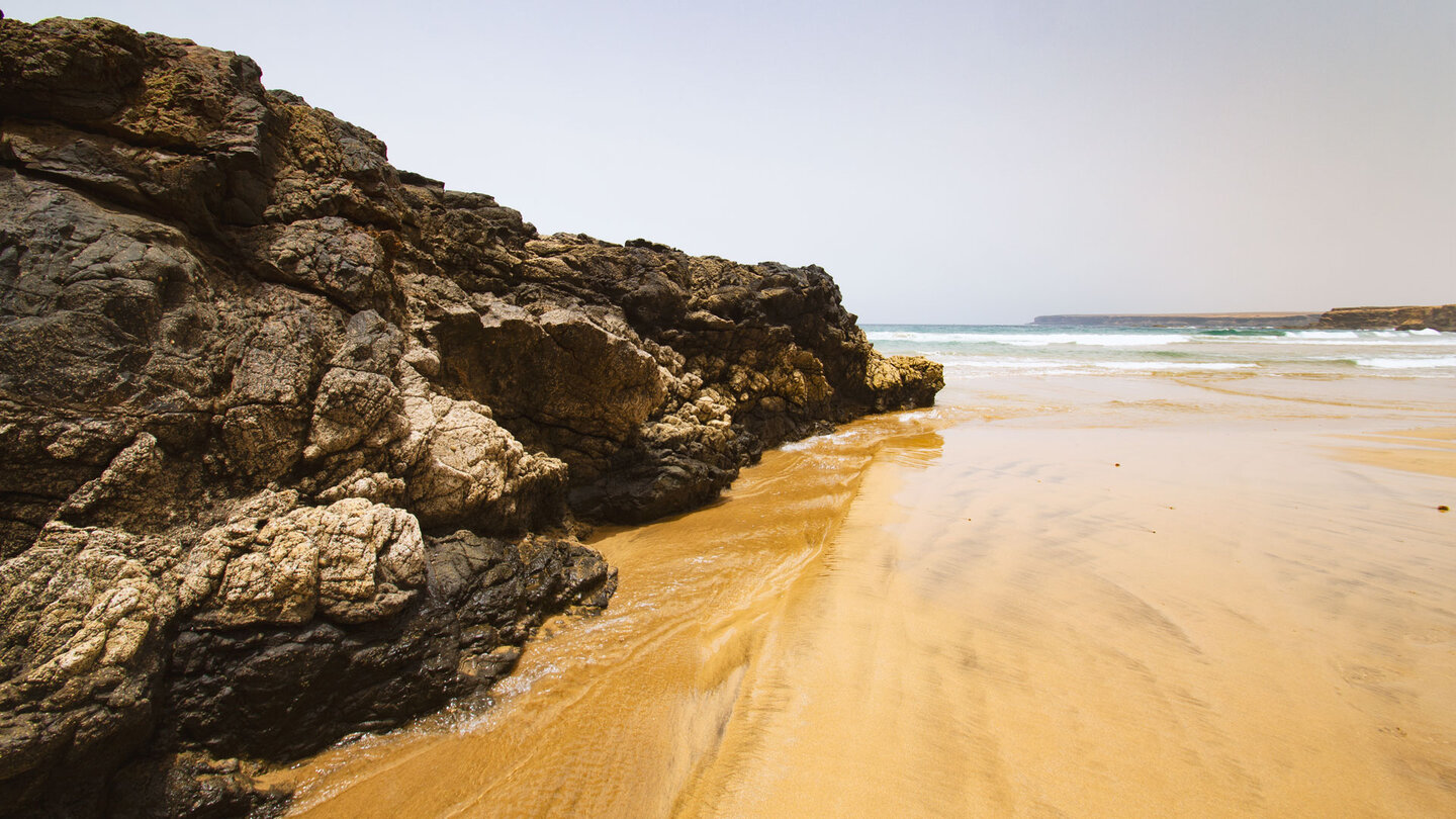 Flutrinne entlang einer Felsformation am Playa de la MujerBaslat