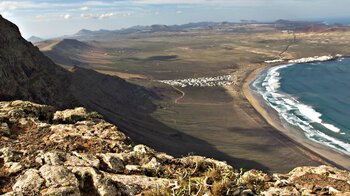 Blick vom Mirador de Bosquecillo auf Lanzarote über die Bucht von Famara mit dem Vulkanpark und Timanfaya im Hintergund