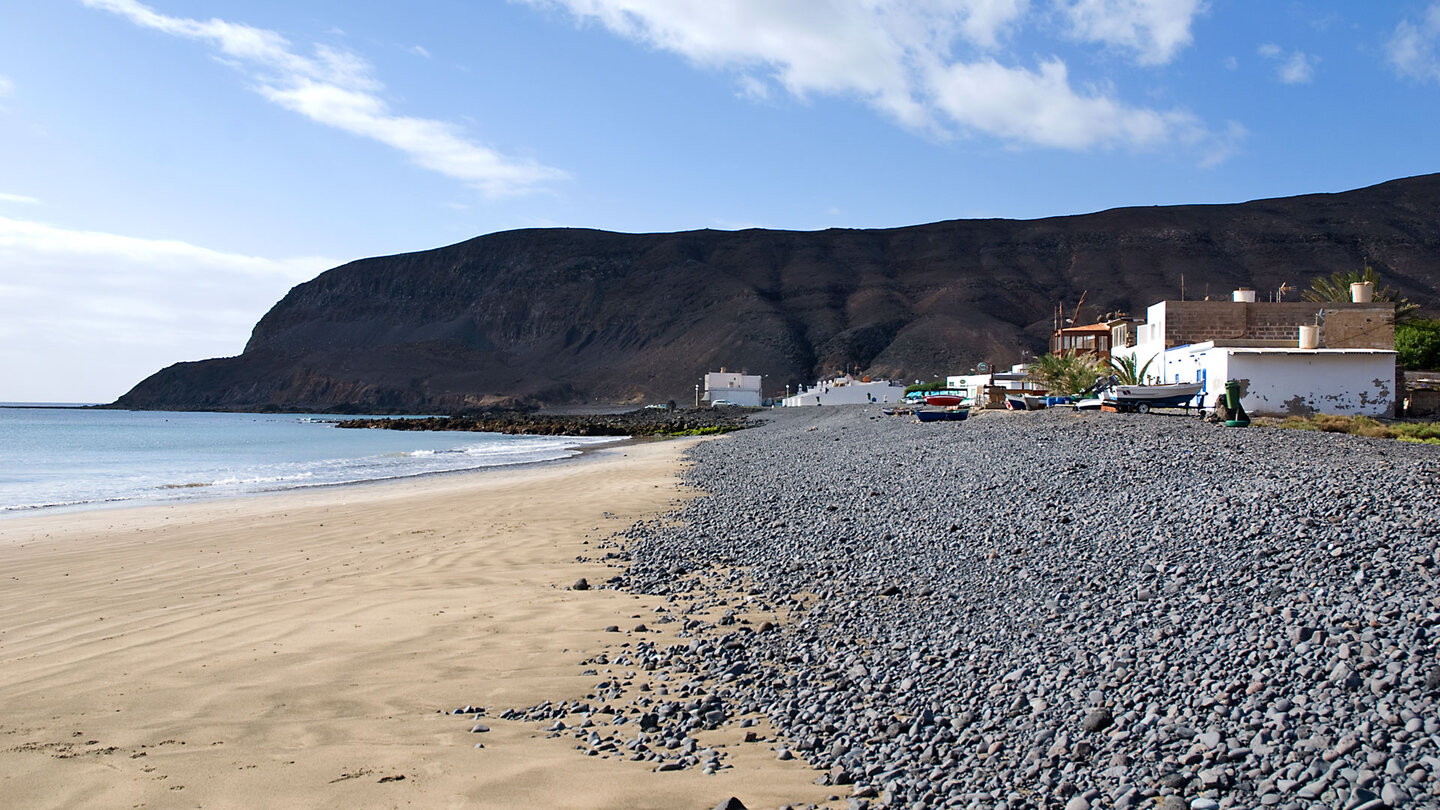 Blick entlang der Bucht mit Fischerhäusern an der Playa de Pozo Negro auf Fuerteventura