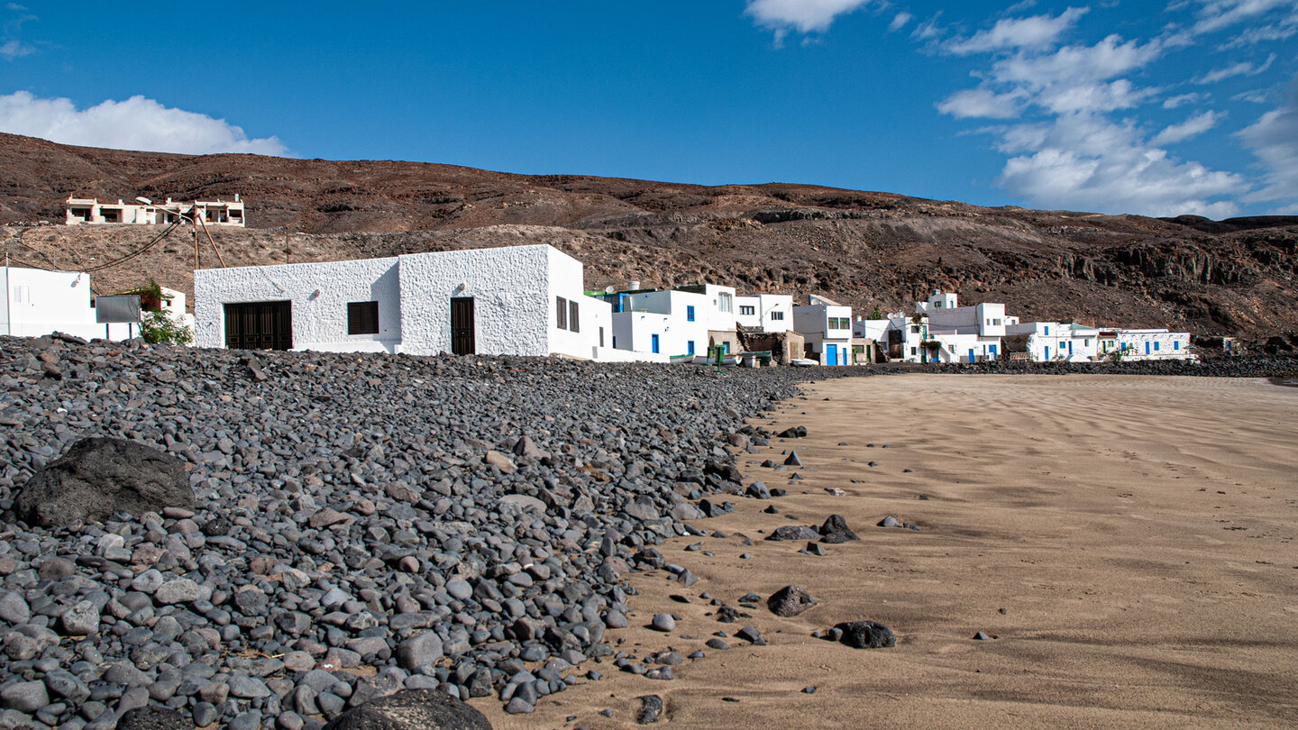 dunkle Kiesel säumen die Strandlinie von Playa Pozo Negro auf Fuerteventura