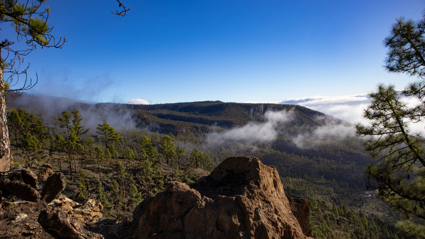 traumhafter Ausblick über Felsen und Wälder mit aufsteigenden Wolken