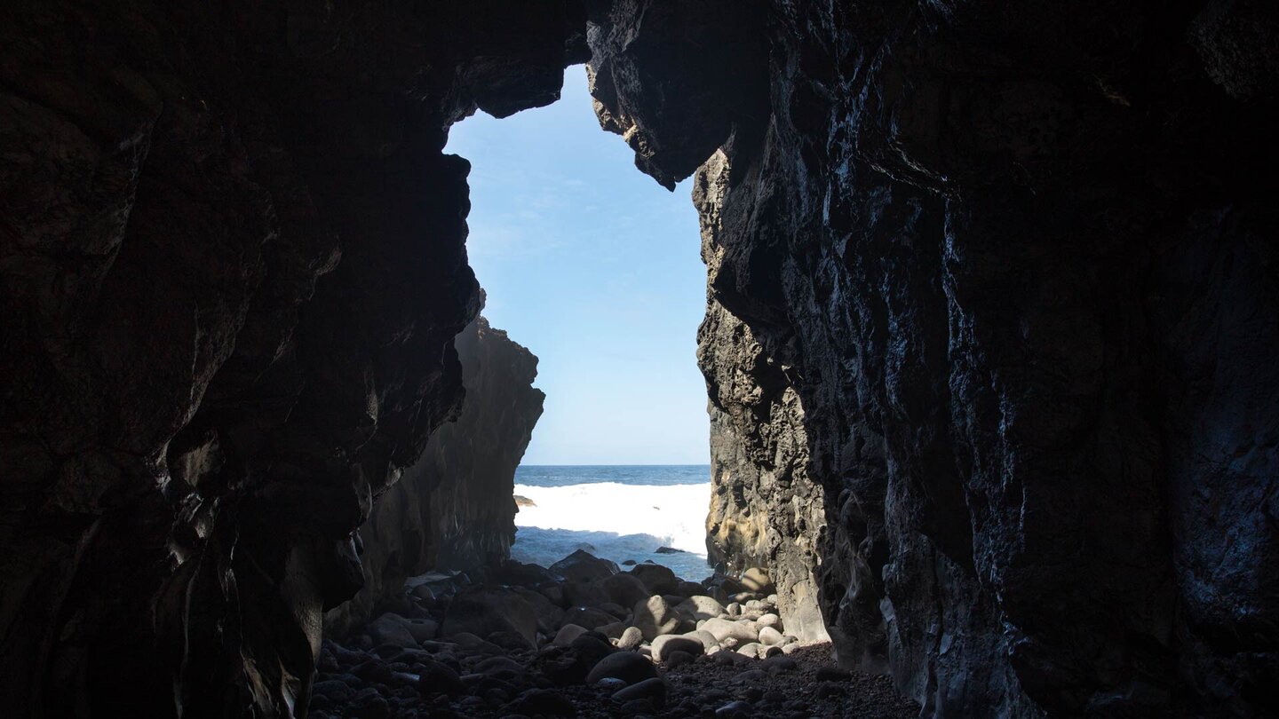 ein Lavatunnel im Basaltgestein mit Blick auf den Atlantik beim Charco Azul de los Llanillos auf El Hierro