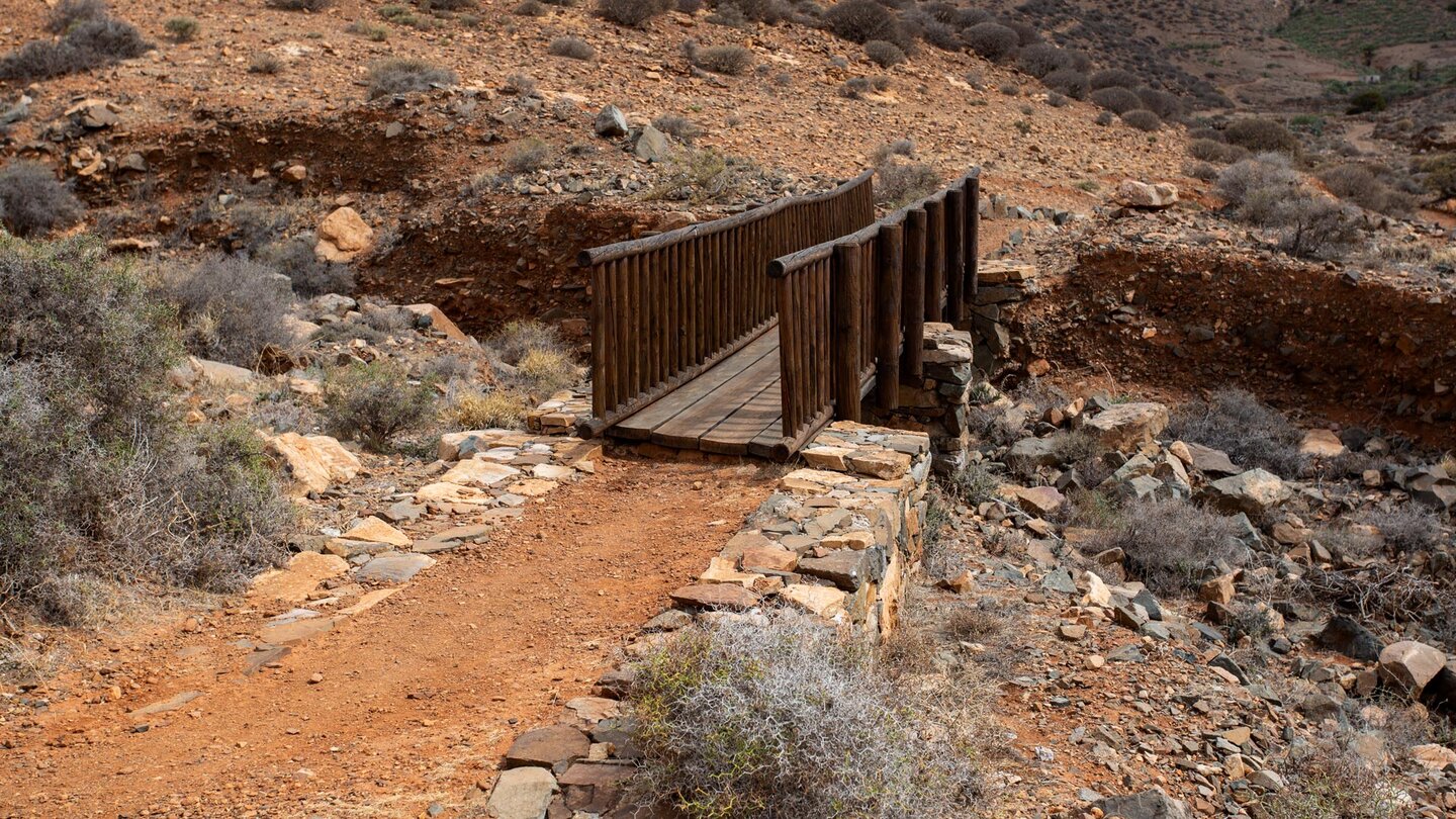 der Wanderweg GR 131 quert ein Bachbett über eine Brücke