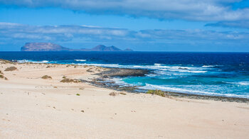 Blick über den Strand Playa del Ámbar auf die Insel Alegranza