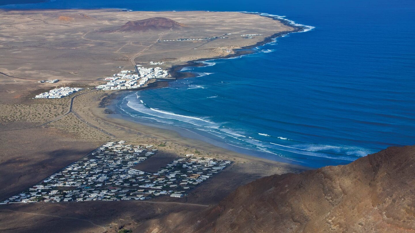 Bucht von Famara mit Feriensiedlung und dem Fischerdorf Caleta de Famara weiter hinten