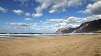 Blick vom Playa de Famara auf Lanzarote entlang der Klippen von Famara bis hin zur Insel La Graciosa