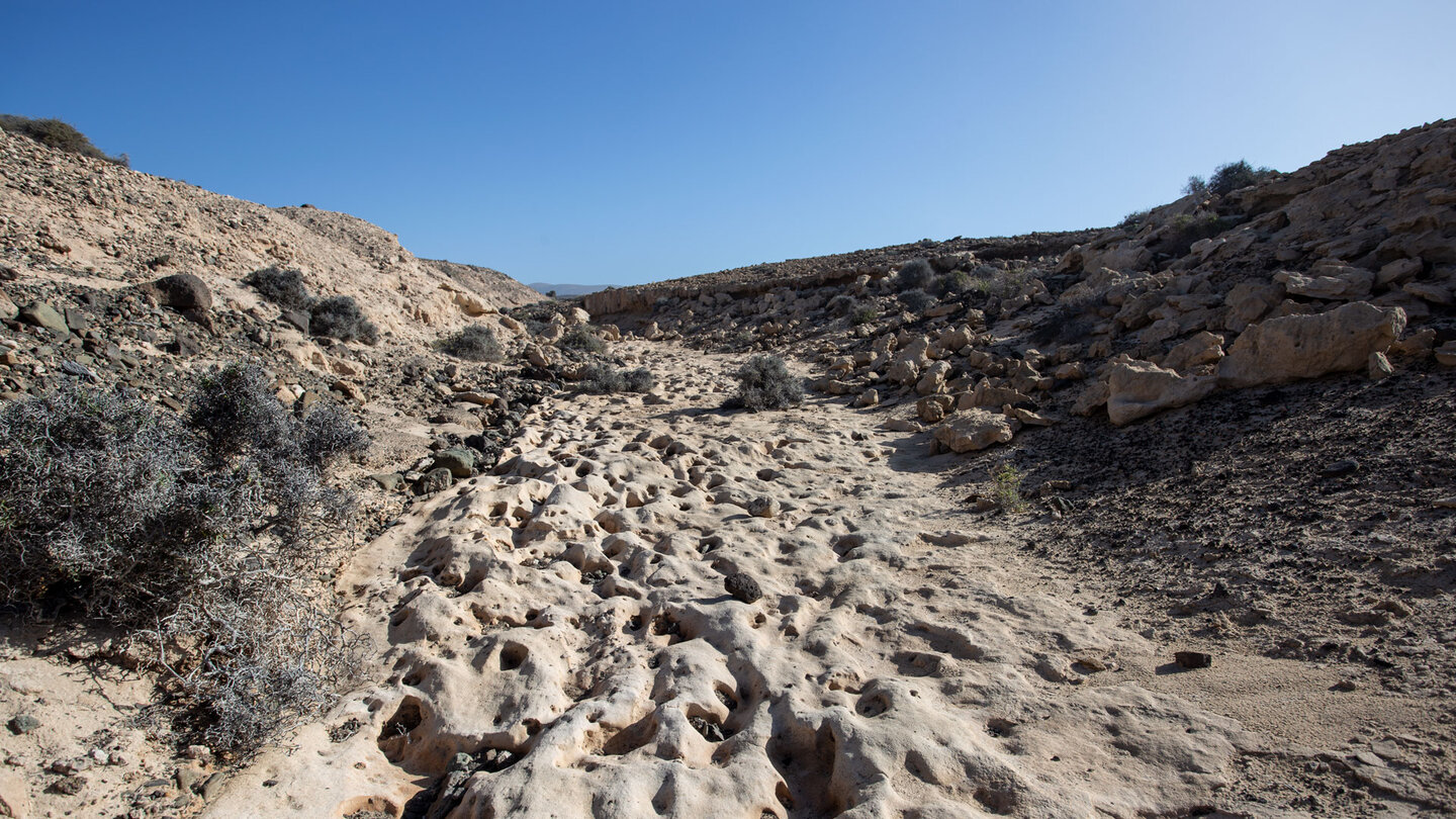 Wanderweg durch eine flache Schlucht mit Kalksteinformationen