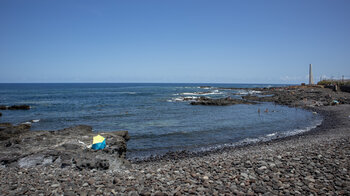 felsige Strände bei Punta del Hidalgo auf Teneriffa mit dem Leuchtturm im Hintergrund