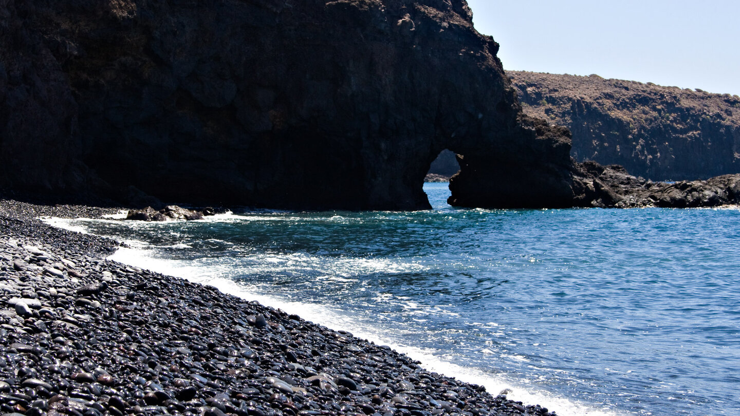 Blick auf das Felstor in der Steilwand an der Playa del Medio