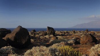 karge Vegetation zwischen gewaltigen Felsen an der Playa de Arenas Blancas auf El Hierro