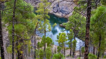 grün schimmerndes Wasser im Stausee Presa del Vaquero