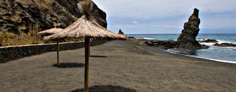 Sonnenschirme am Strand der Playa de la Caleta