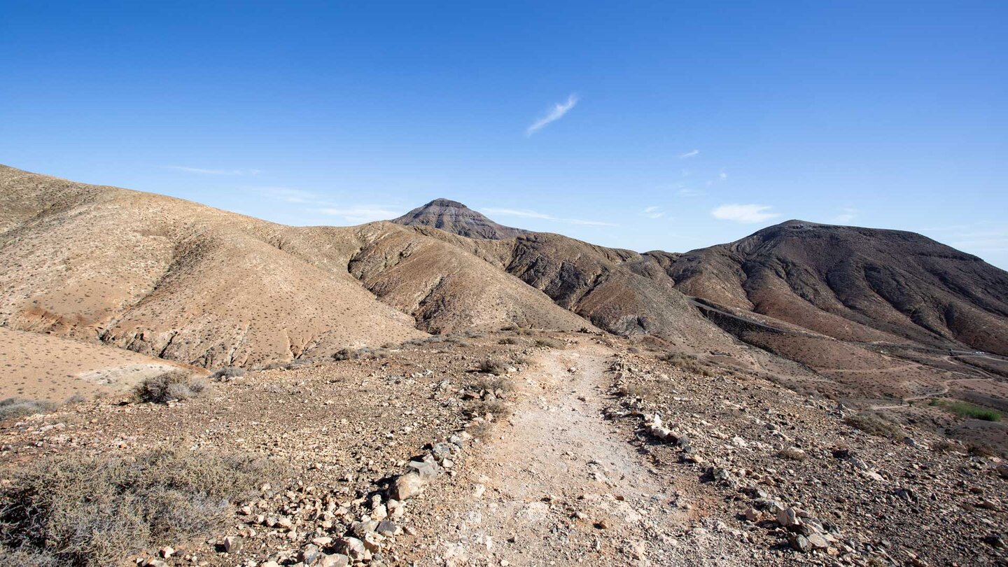 der mit Steinen begrenzte Wanderweg SL FV 10 entlang des Höhenrückens