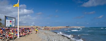 Blick entlang des gut besuchten Strands der Playa de Maspalomas auf Gran Canaria