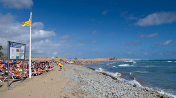 Blick entlang des gut besuchten Strands der Playa de Maspalomas auf Gran Canaria