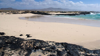 schwarze Lavazungen bilden den Kontrast zum hellen Sand an den kleinen Buchten Caletillas de Cotillo auf Fuerteventura